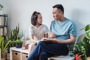 father reading book to his daughter 