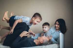 parents playing with kids on the bed