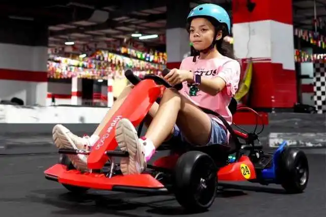 Girl riding a go kart outside