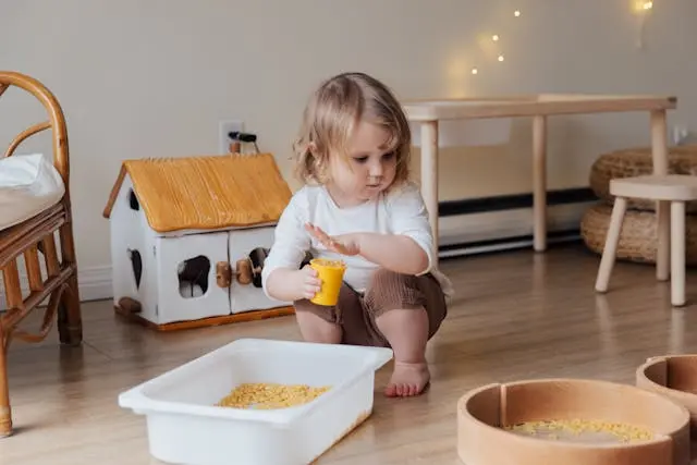 Child playing with sand- sensory play for infants