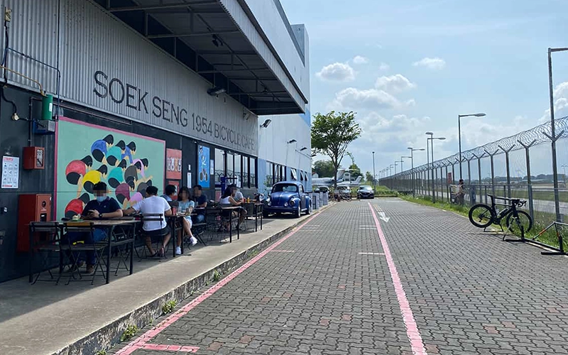 Casual outdoor dining spot along an airport runway, with a bicycle-themed interior.